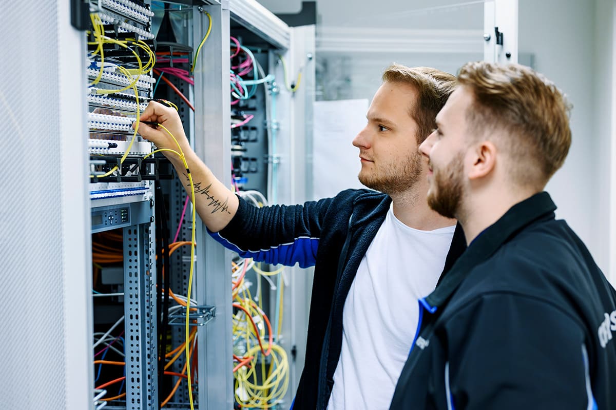 Zwei Kollegen arbeiten mit Netzwerkkabeln.