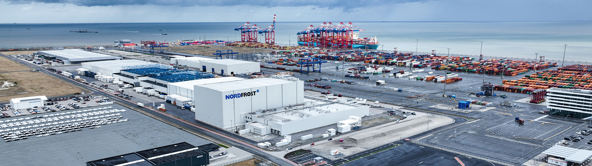 Nordfrost-Lager aus der Vogelperspektive mit Containern und Schiffen.