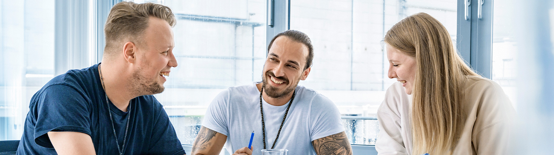 Drei Angestellte an einem Konferenzraum