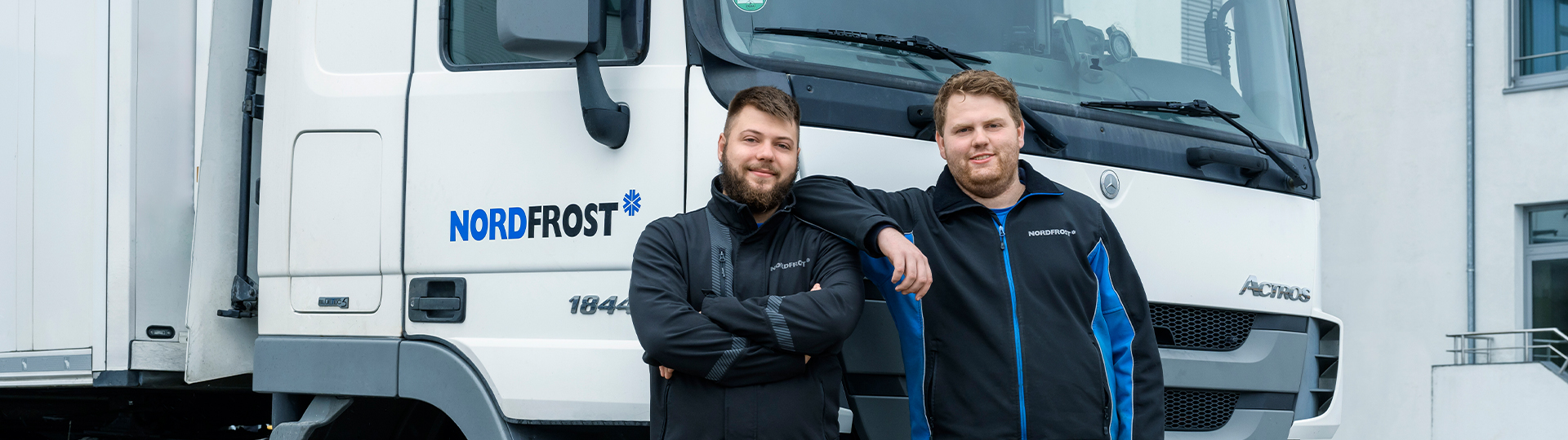 Lächelnde Mitarbeiter, die vor einem LKW stehen