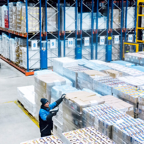 Paletten, Mitarbeiter und Gabelstapler im Hochregallager