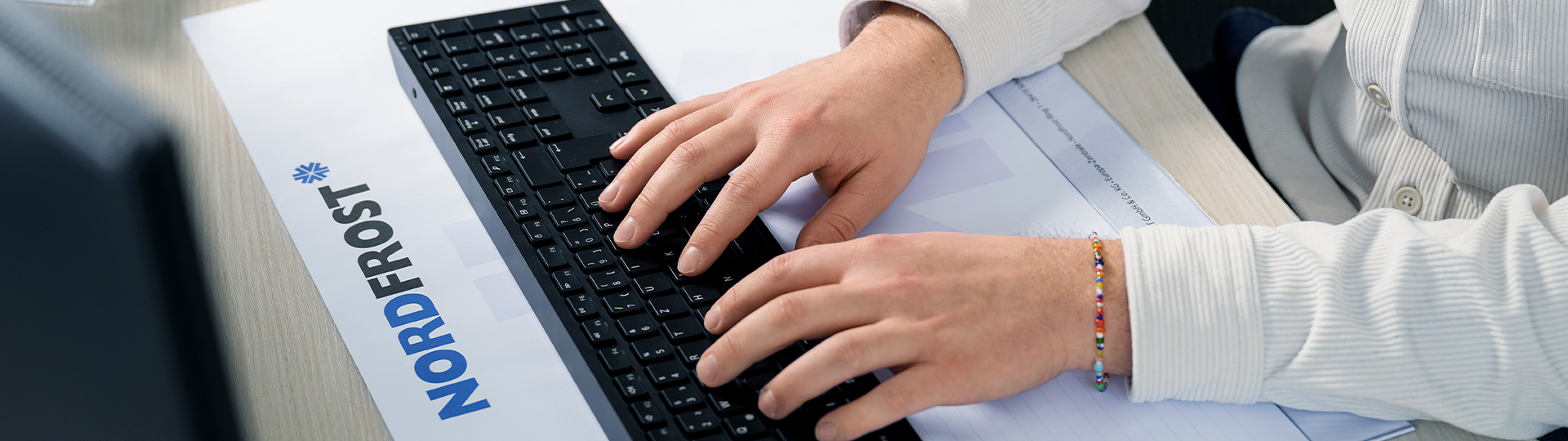 Verwaltungsmitarbeiter an der Tastatur am Arbeitsplatz